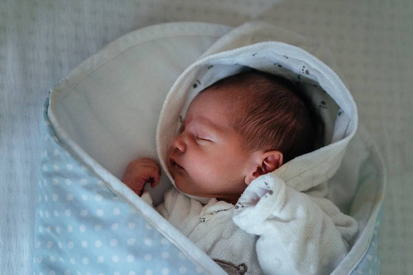 Newborn baby boy asleep in a blue blanket