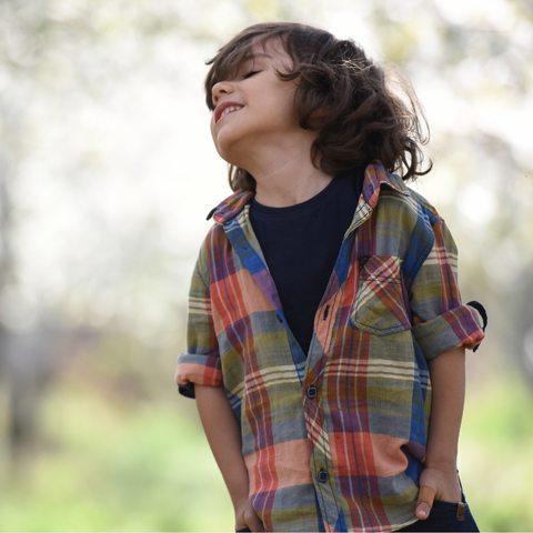 A young boy wearing a black t shirt and colourful shirt