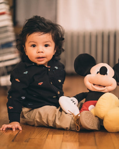 a young boy holding a Disney Mickey mouse toy