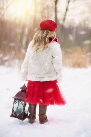girl in the snow wearing christmas coat