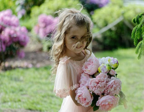 Girl holding a bunch of pink roses in a garden