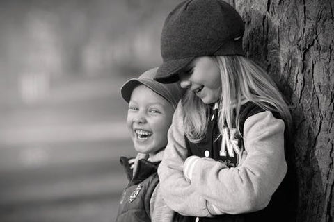 A boy and girl wearing unisex clothing in a black and white shot