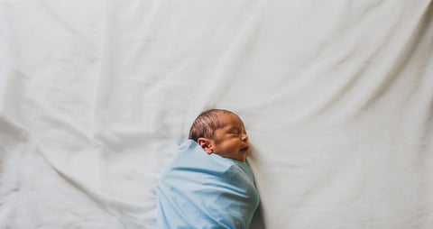 newborn baby boy wrapped in a blue blanket