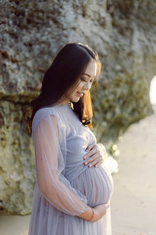 pregnant woman wearing a white dress on the beach