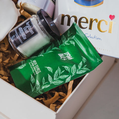 A collection of gifts in a white gift box with Urban Duck's scrub and mask being the main focus