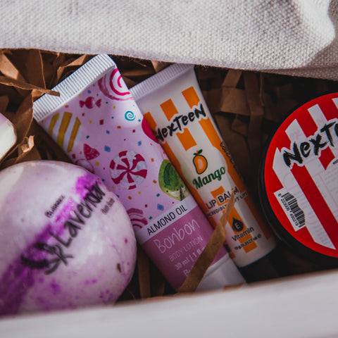 Collection of gifts inside a white gift box, with the body lotion and lip balm being the focus.