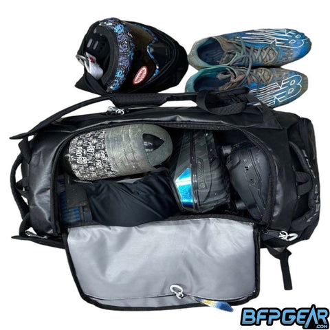 An open AW Gear Backpack full of paintball equipment.