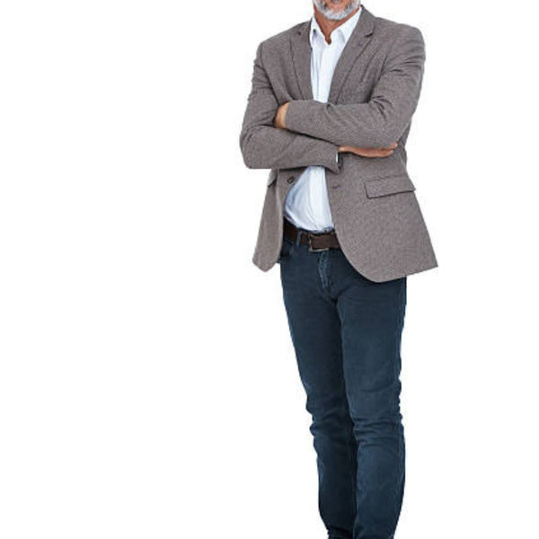 man with a grey blazer, white button-down shirt, dark wash jeans, and brown dress shoes