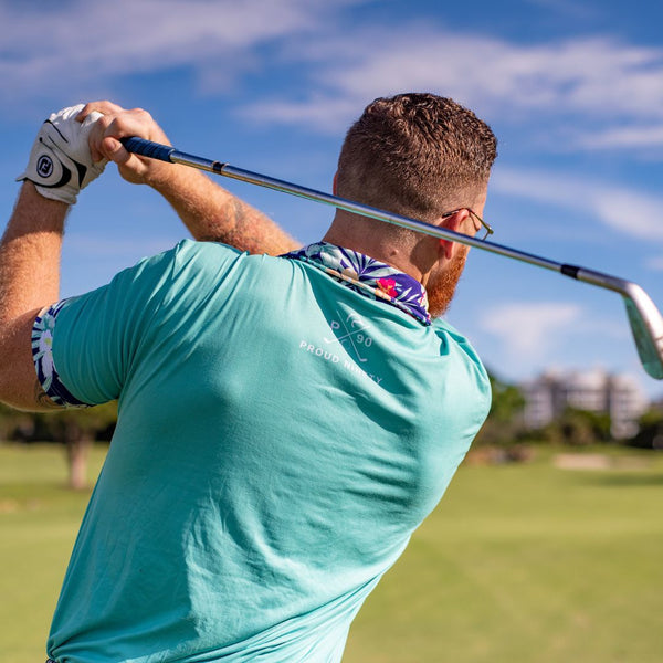 man golfing with a blue polo shirt featuring a floral collar and sleeve trim.