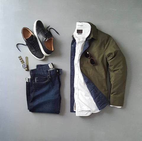 Men’s jeans, shoes, watch, shirt, and jacket laid out.