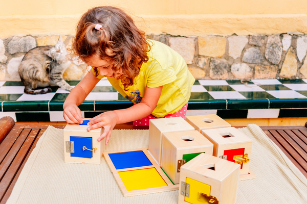 A young gild playing with montessori toys and trying to solve the challenge they present