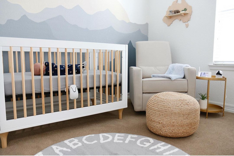 Nursery in neutral colors. A baby in its cot and a Babysense 7 breathing movement monitor is connected to the cot.