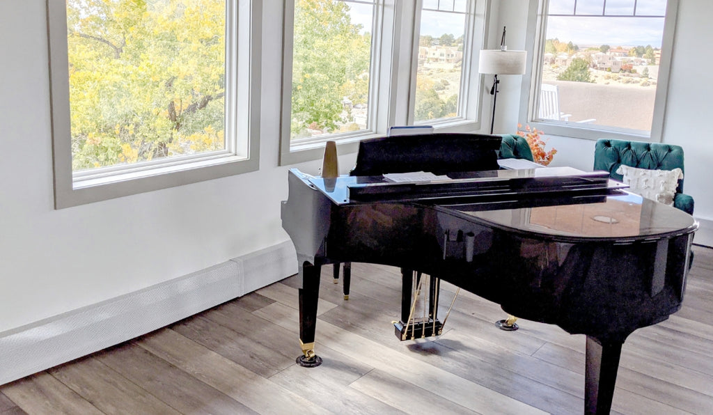 Large room with big windows and a black grand piano.