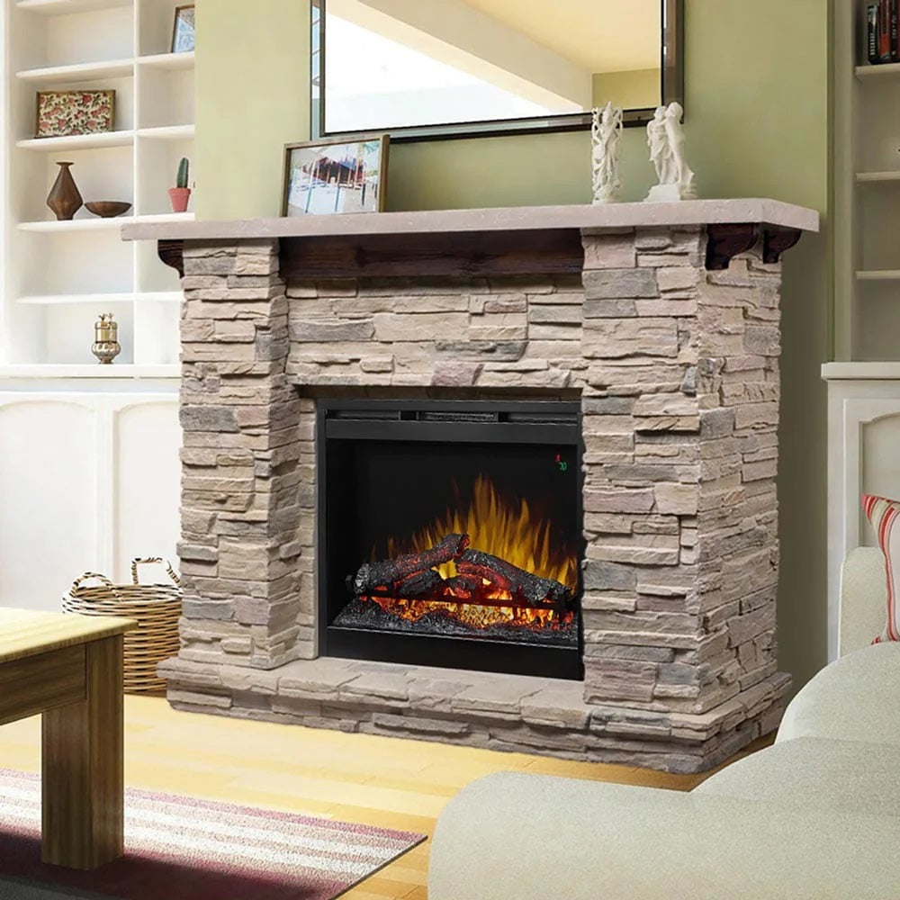 Stacked stone electric fireplace with wood mantel and sage green wall behind.