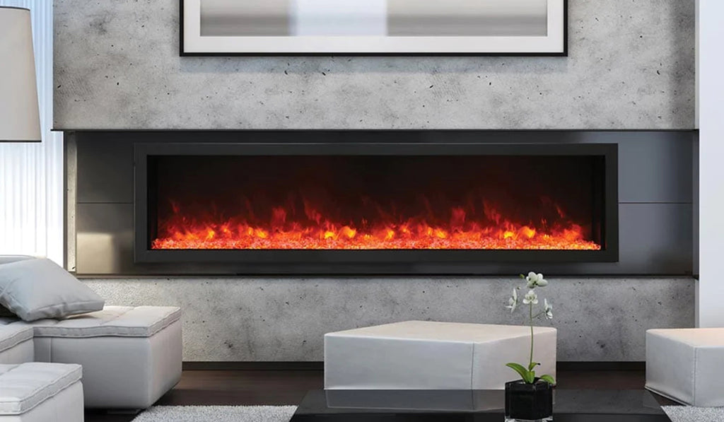 Extra long electric fireplace fully recessed in the wall with gray stone on the wall and living room furniture in the foreground.