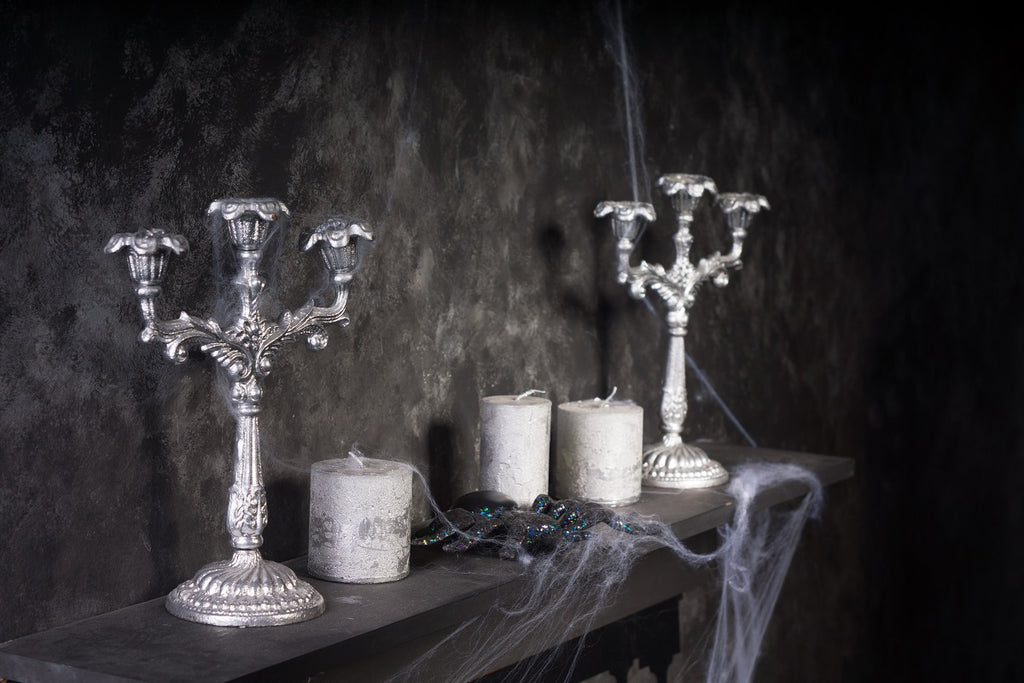 Spooky candelabras and candles on a mantel.