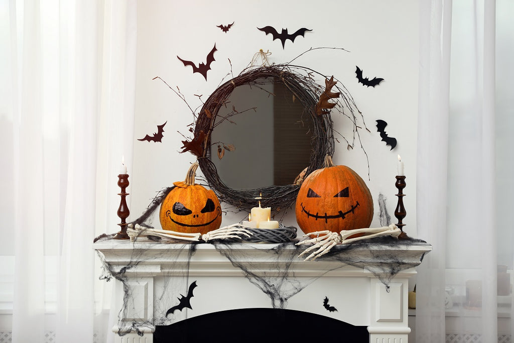 Bats and pumpkins over a marble mantel.