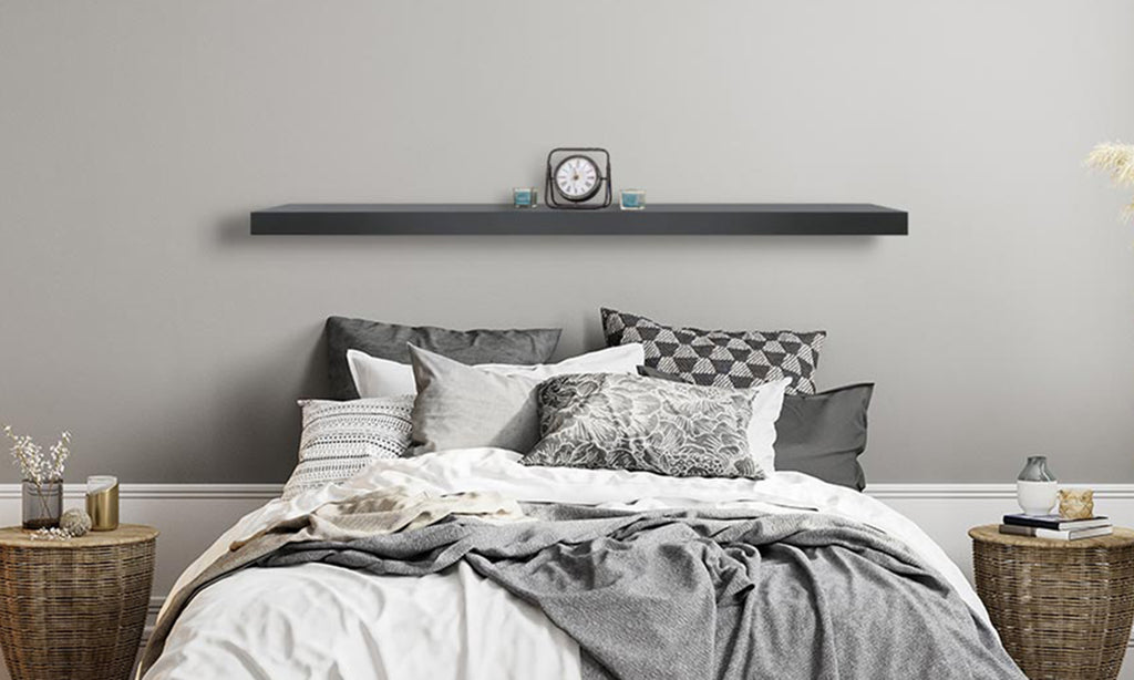 Metal mantel shelf placed over a bed against a light gray wall.
