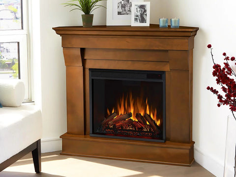 Wood mantel electric fireplace placed in the corner of a bright living room.