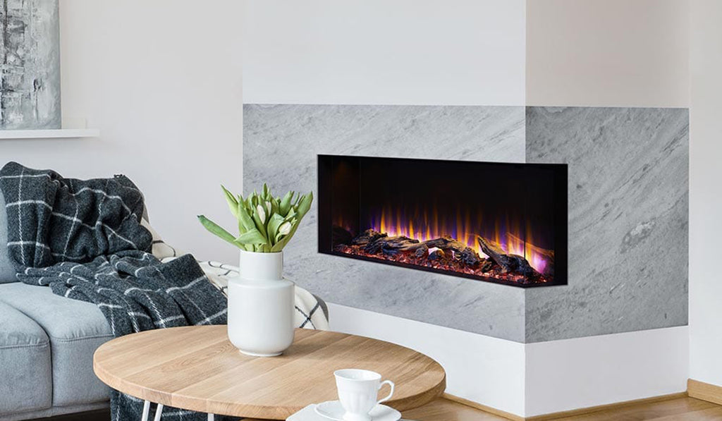 Three sided electric fireplace in a white wall with gray stone surround and no mantel.