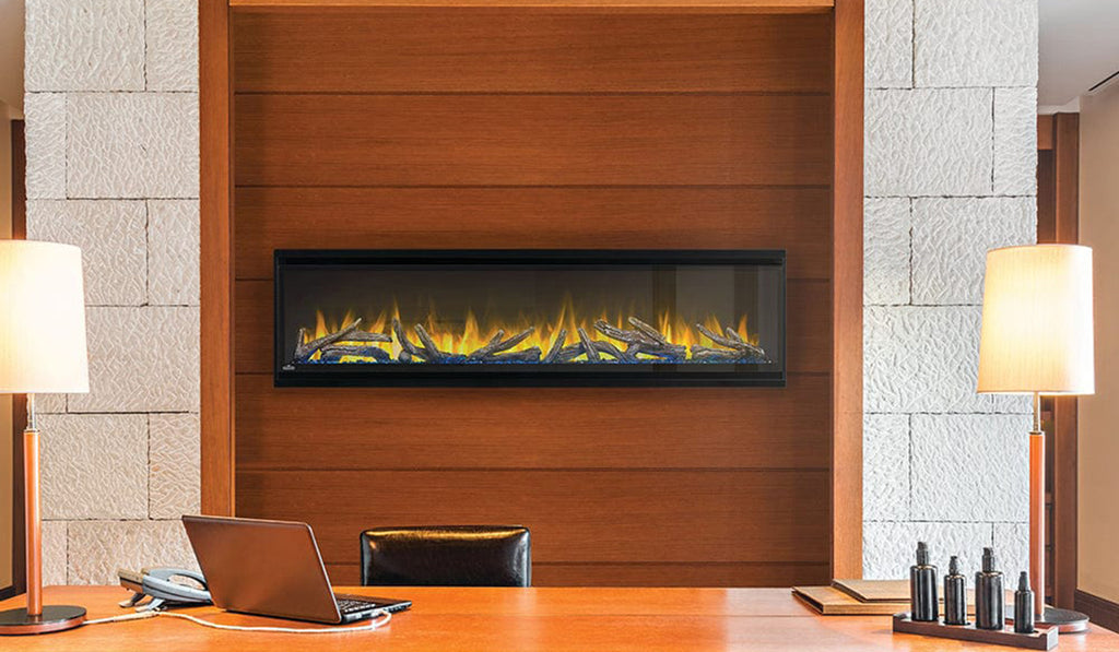 Surface mounted electric fireplace in a wall with wood surround and lamps on either side. 