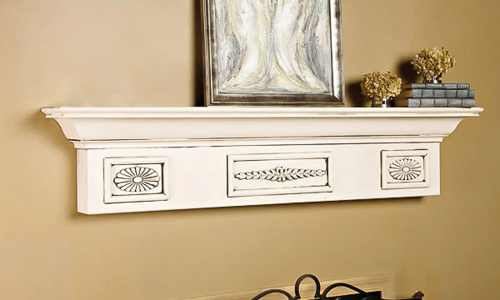 Vintage-inspired wood mantel shelf painted white with decor on top.