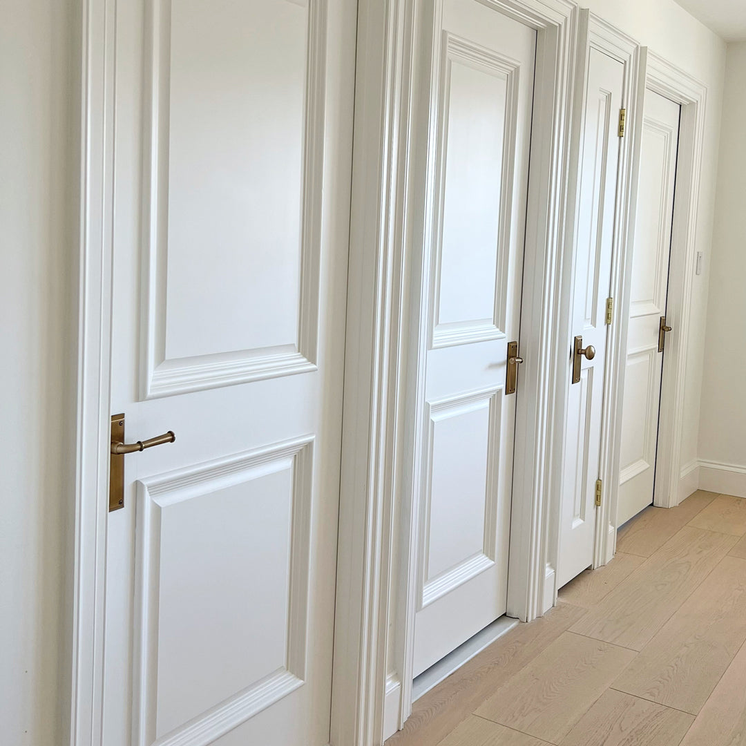 white doors hallway brass door hardware