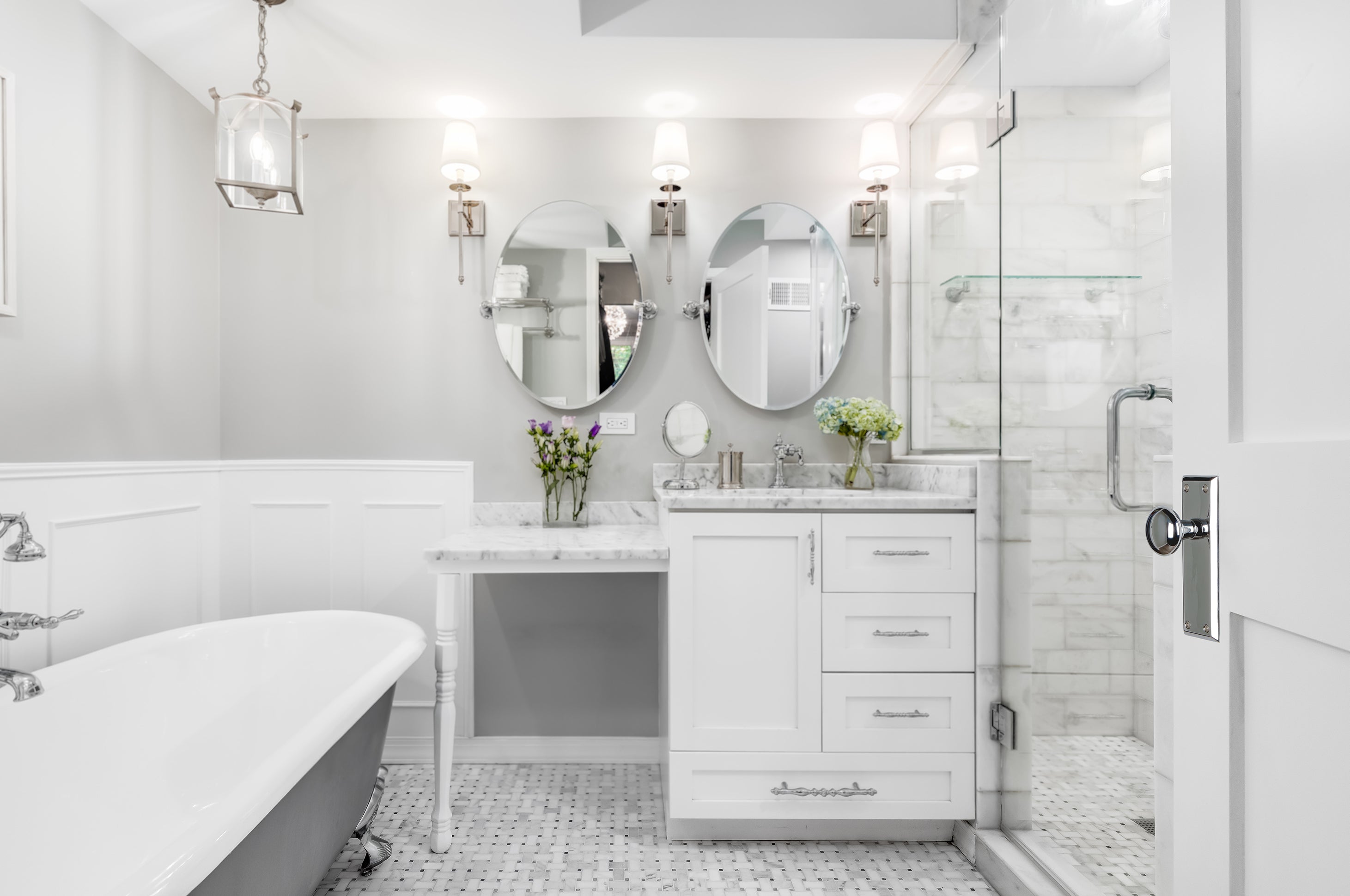 Crisp white bathroom with bright chrome hardware. A Grandeur Fifth Avenue Long Plate with Fifth Avenue Knob in in Bright Chrome.