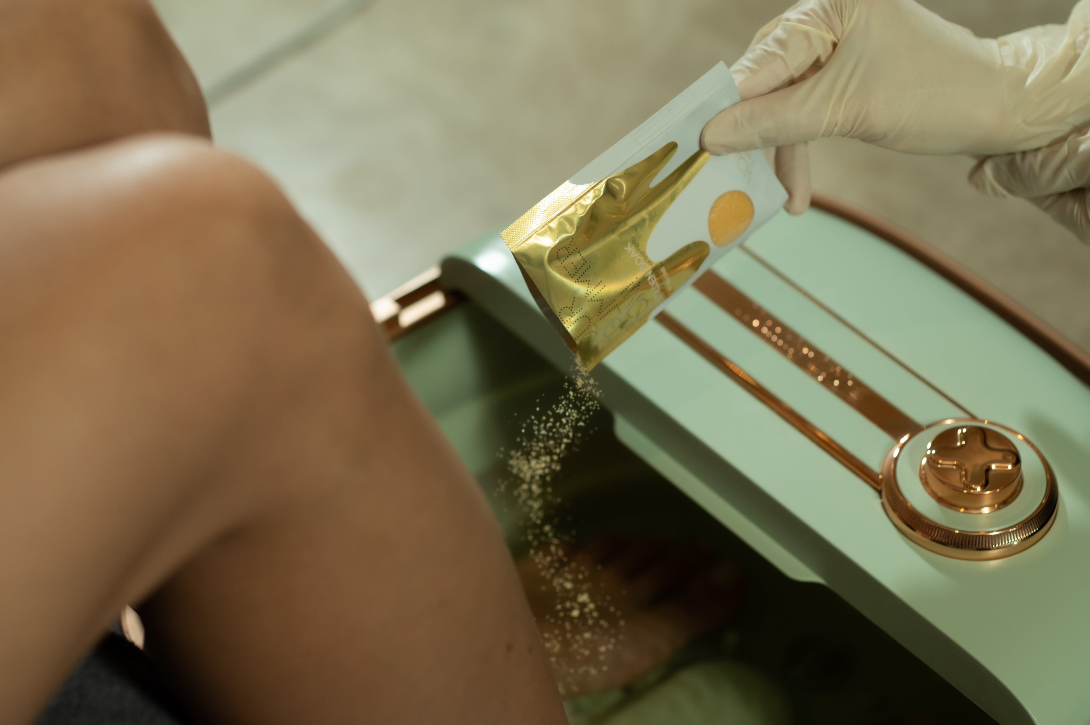 womans feet in foot bath as the foot soak ingredients are being poured in