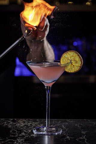 Cosmo pink cocktail garnished with Silver Tongue Foods dried lime wedge