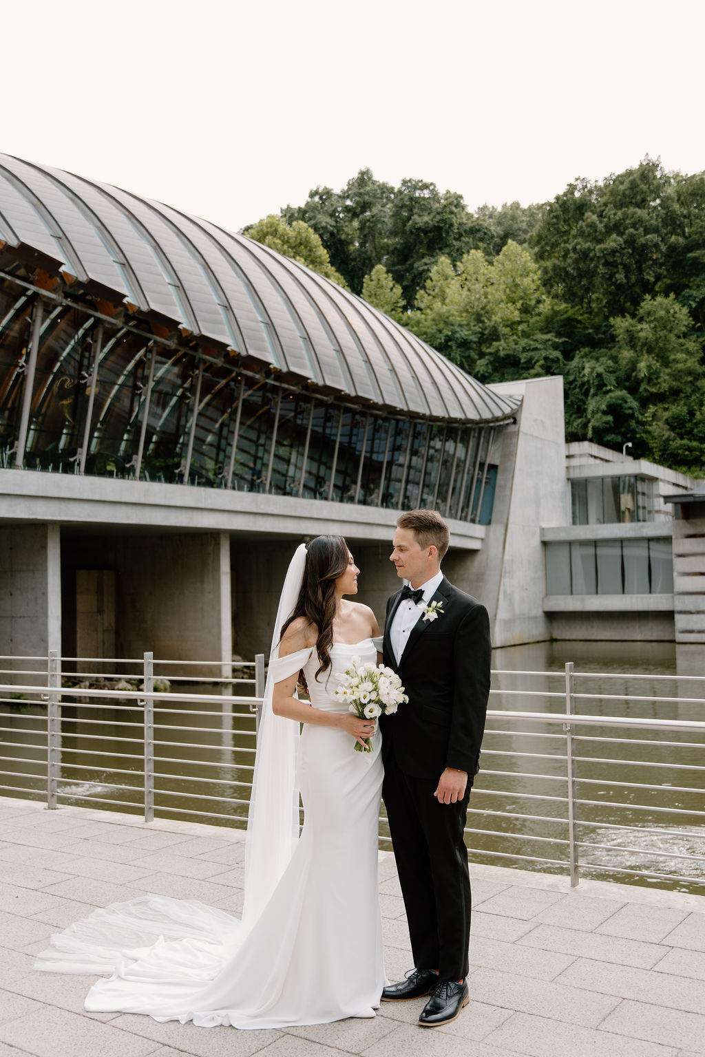 Bride and Groom take portraits with bridal bouquet by Earth and Thorn at Crystal Bridges Museum for their wedding