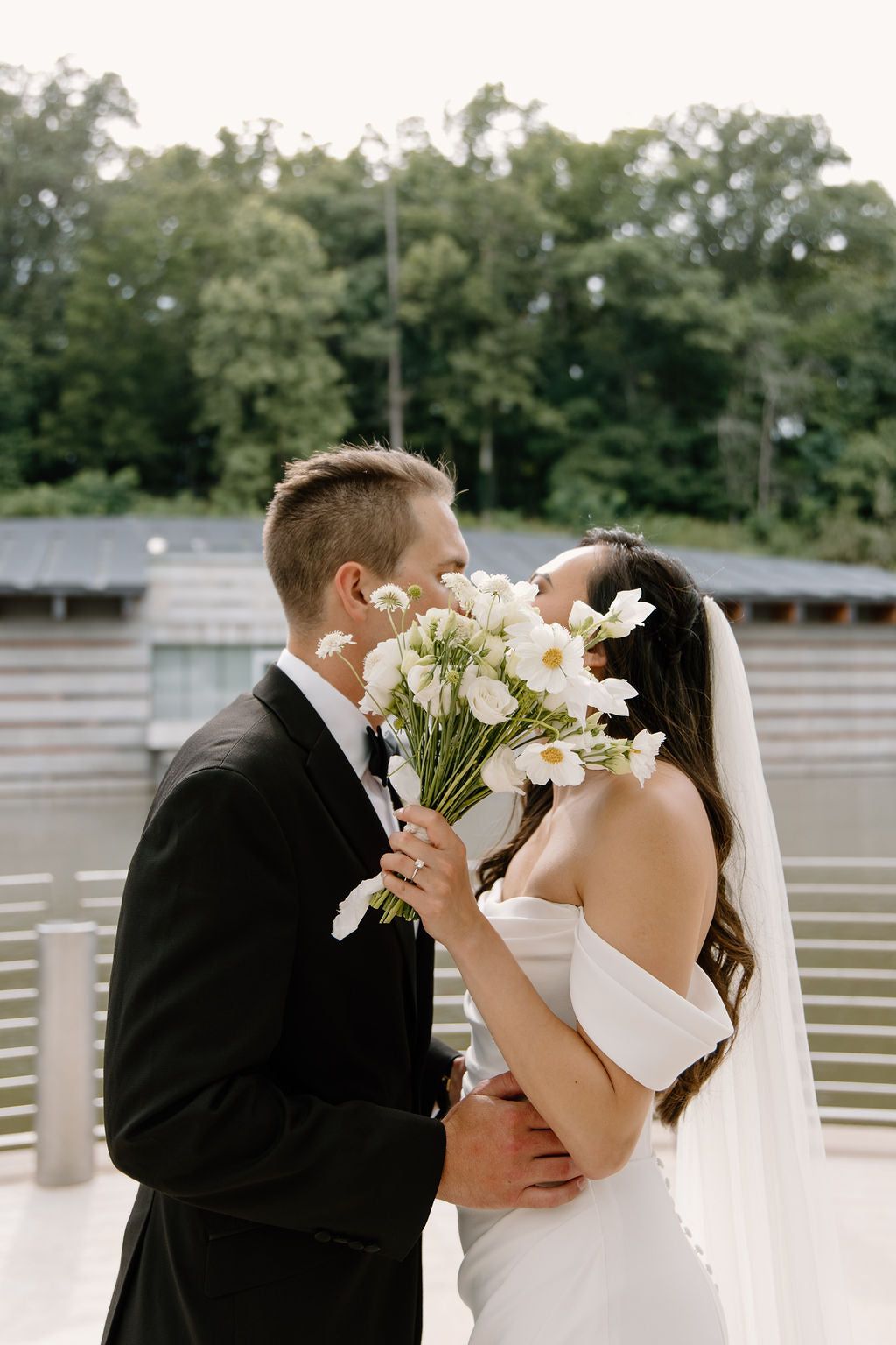 Bride and groom holding a wedding bouquet by Earth and Thorn at Crystal Bridges