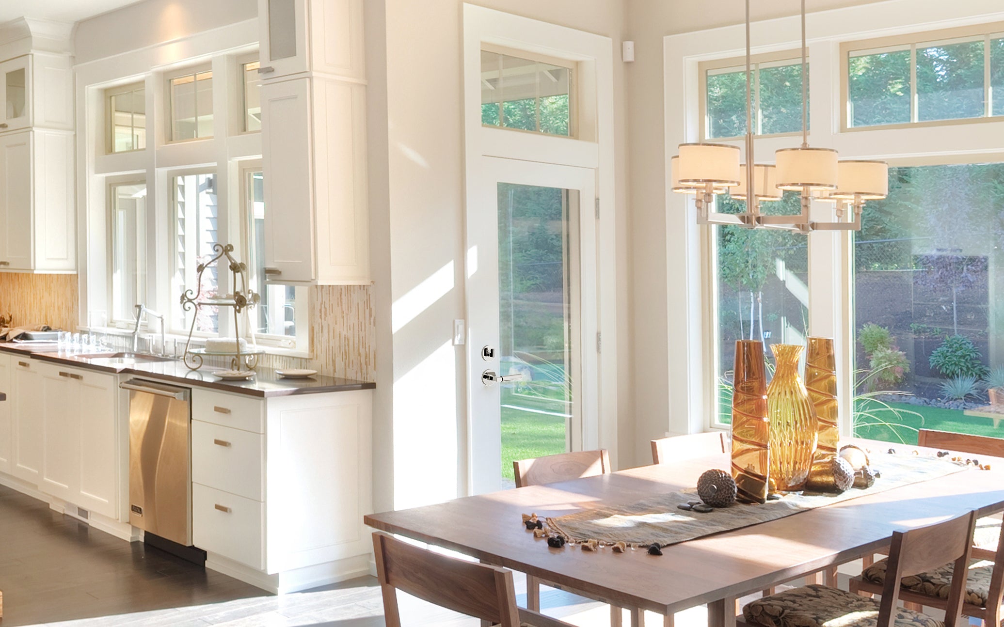 Kitchen on the left, dining table on the right with a door that leads outside in the middle. The door has Viaggio's Circolo Rosette Entry Set with Contempo Lever in Bright Chrome on it.