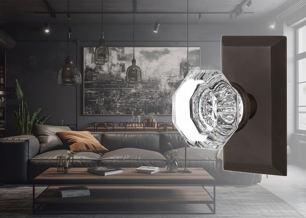 A dark and moody living room with a Nostalgic Warehouse Studio Short Plate with Waldorf Crystal Knob in Oil-Rubbed Bronze laid over the top of the image on the right.