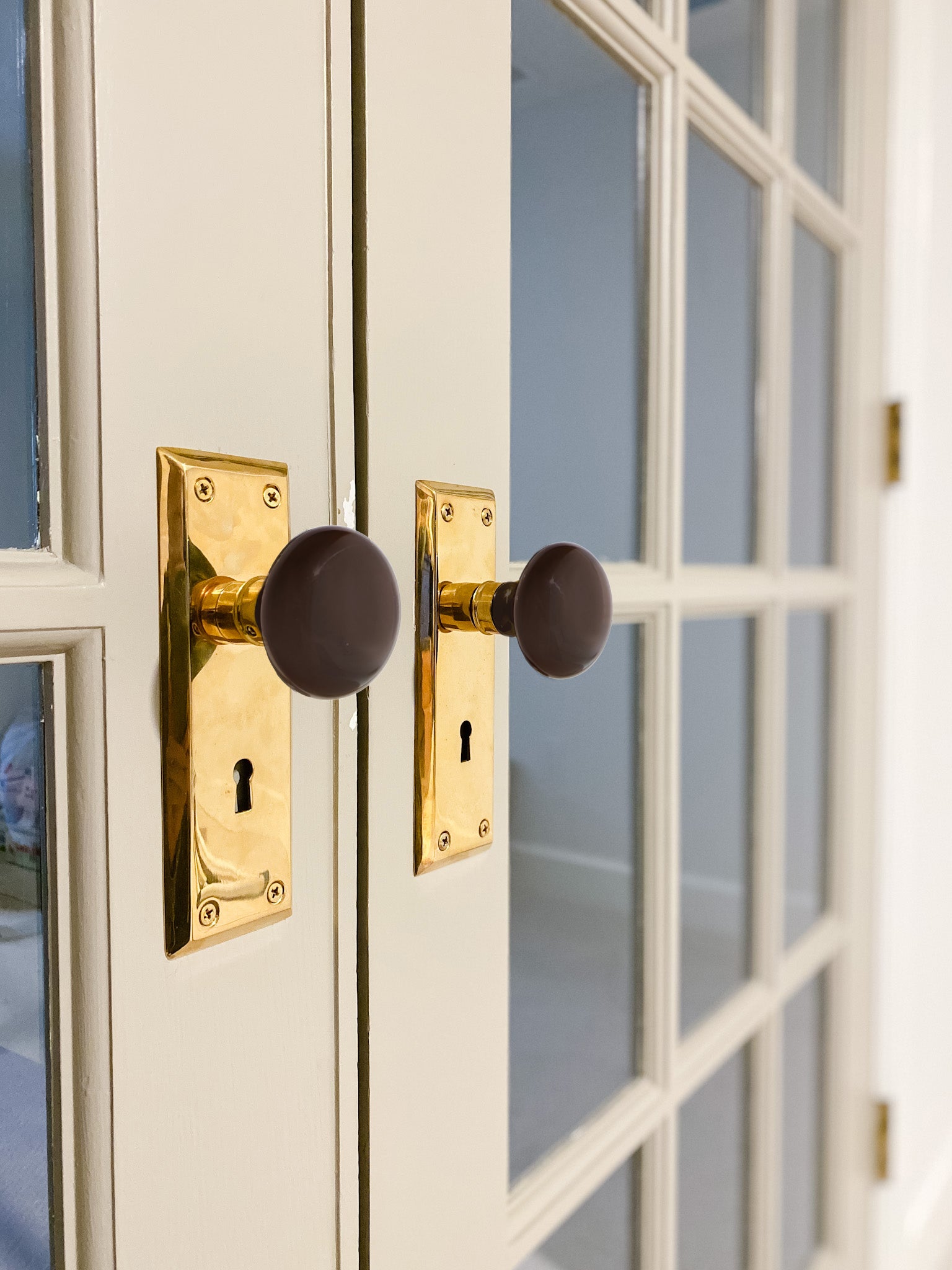 Cream french doors with New York Long Plate with Brown Porcelain Knob in Unlacquered Brass door knobs