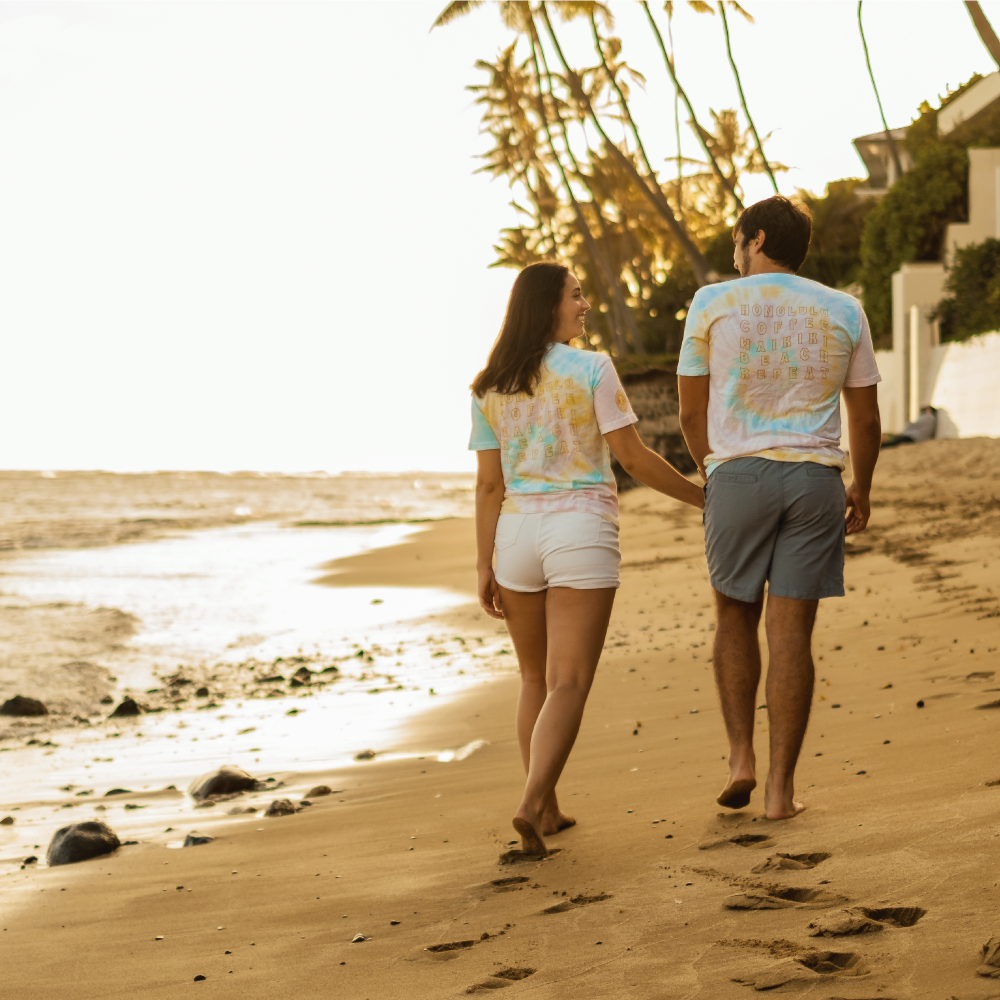 Two people walking on the beach in Honolulu Coffee Tie Dye Shirts