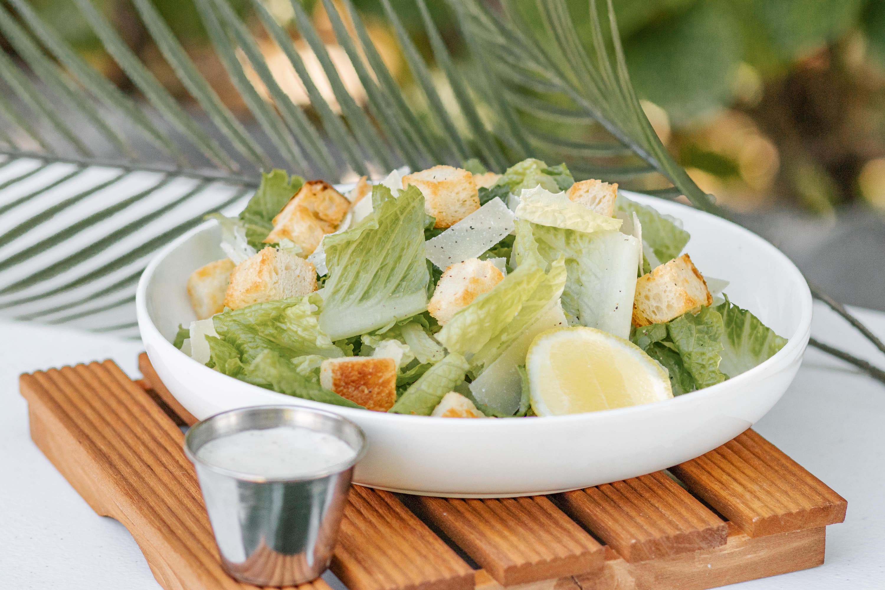 Caesar Salad with romaine lettuce, parmesan shavings, lemon, housemade sourdough croutons, and dressing on the side