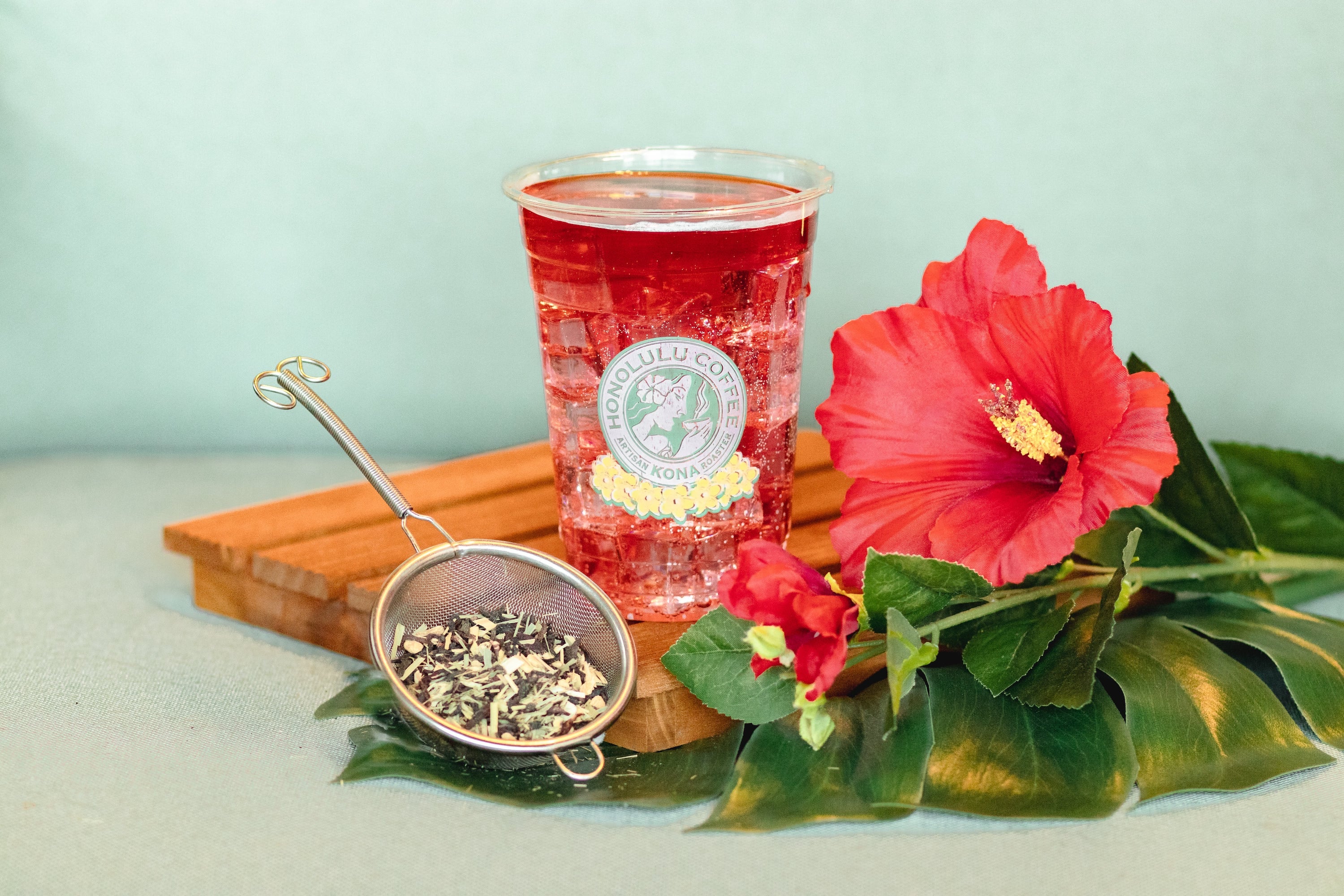 Iced Hibiscus Spritzer next to loose FIrepot Hibiscus tea and a Hibiscus flower