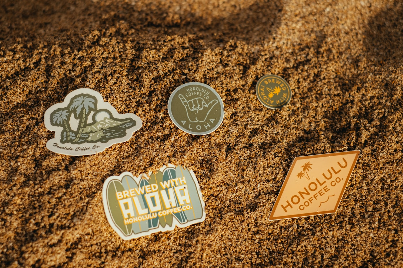 Honolulu Coffee stickers in the sand