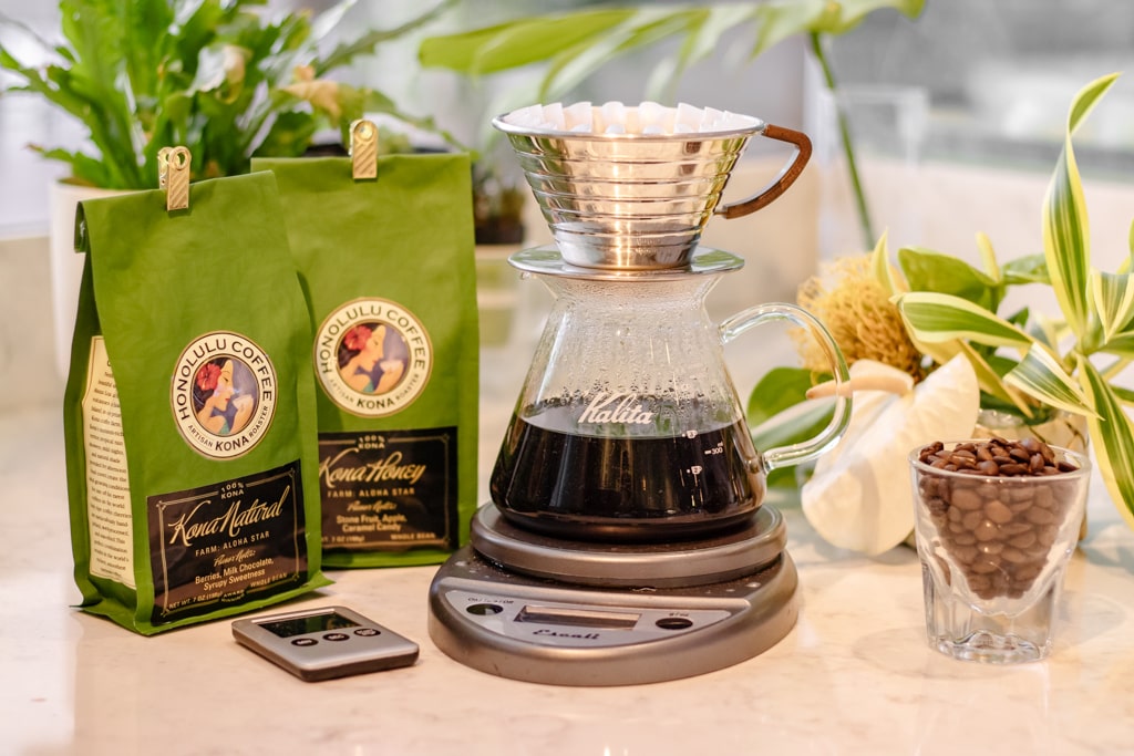 Prepping for a Kalita brew with the following items: A Kalita 185 brewer, Kalita 185 filter, scale, timer, and Kona Natural/Kona Honey coffee beans.