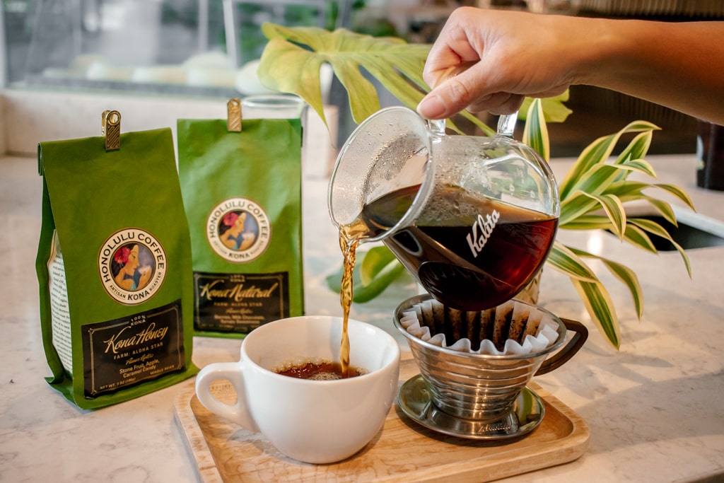 Pouring the brewed coffee from the decanter to serve in a mug.