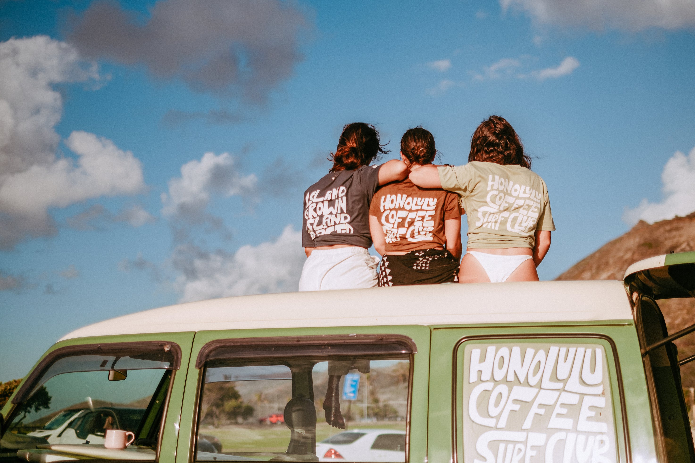 Honolulu Coffee team members sitting on top of the Sue Brew Van