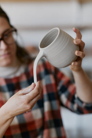 Sofie Neuendorf demonstrating her technique of attaching a handle to a mug.