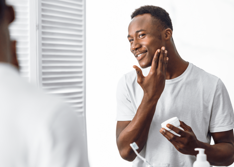 Black man using skincare on face