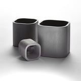 Three gray concrete planters in small, medium, and large sizes.