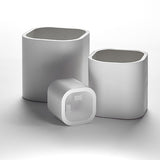 Three white concrete planters in small, medium, and large sizes.