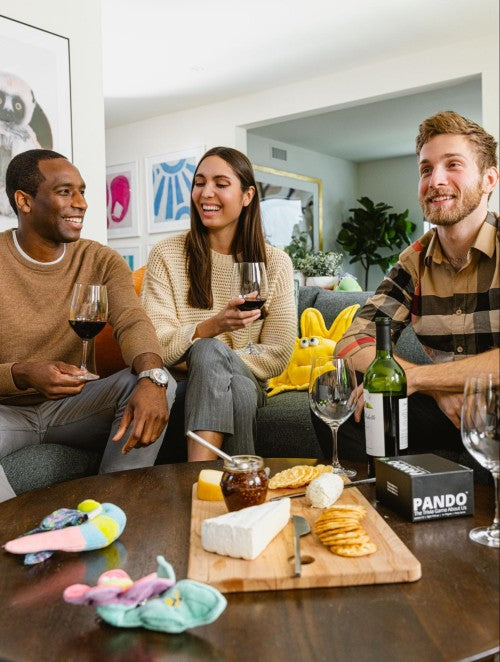 Friends sitting on a couch having a wine and cheese party