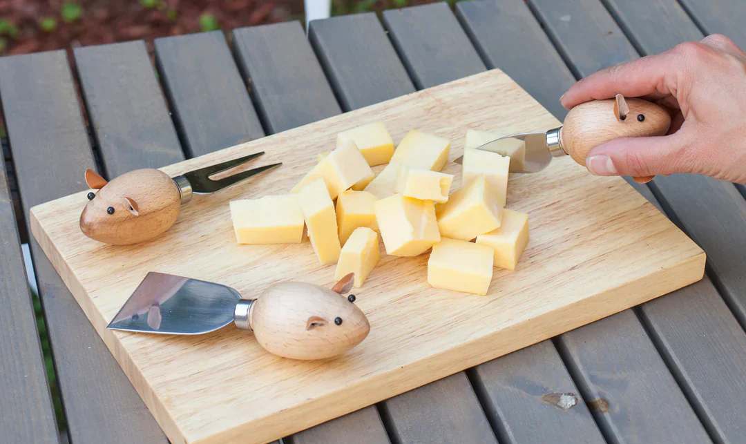 Person using Kikkerland mouse cheese knives