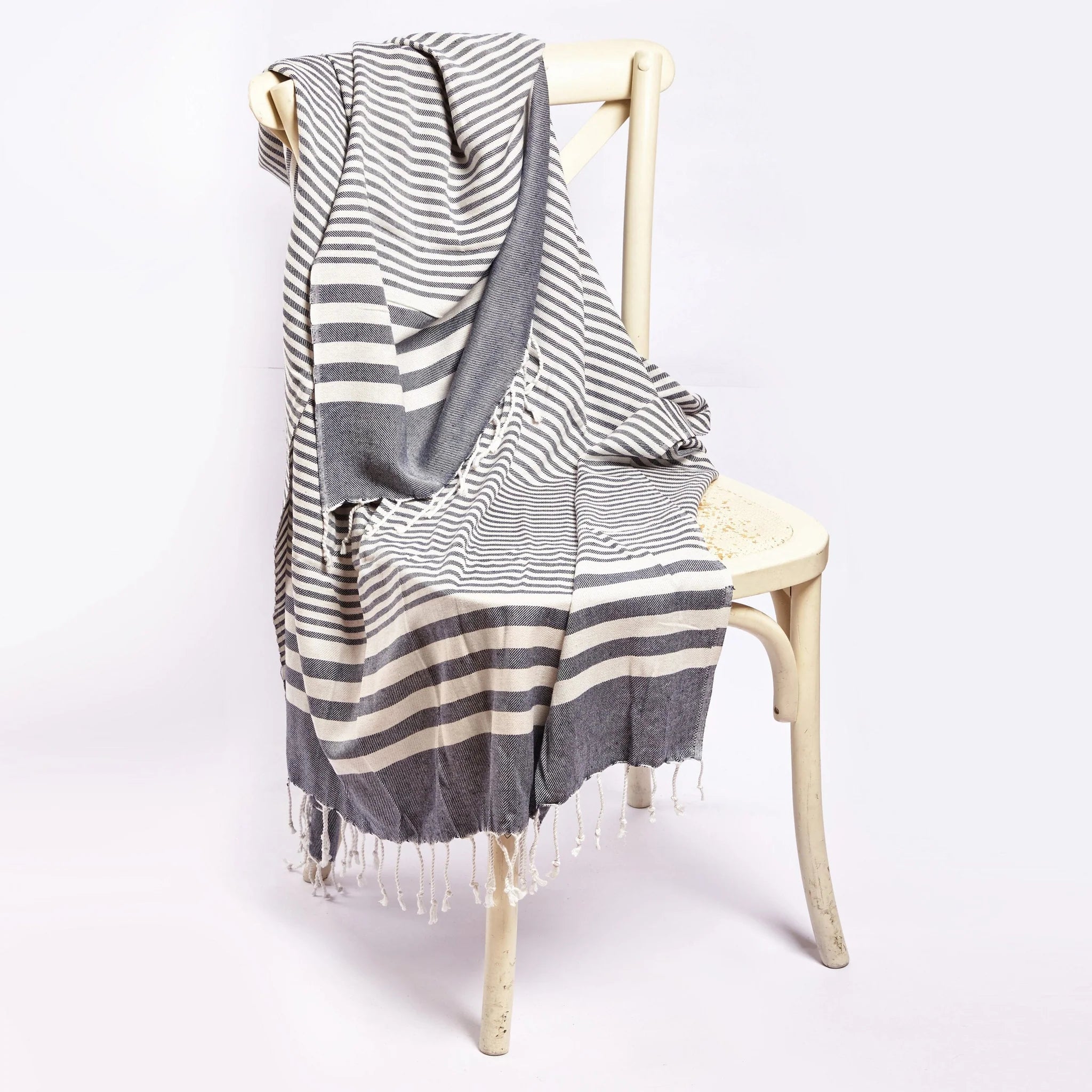 Blue and white striped throw blanket draped over white chair