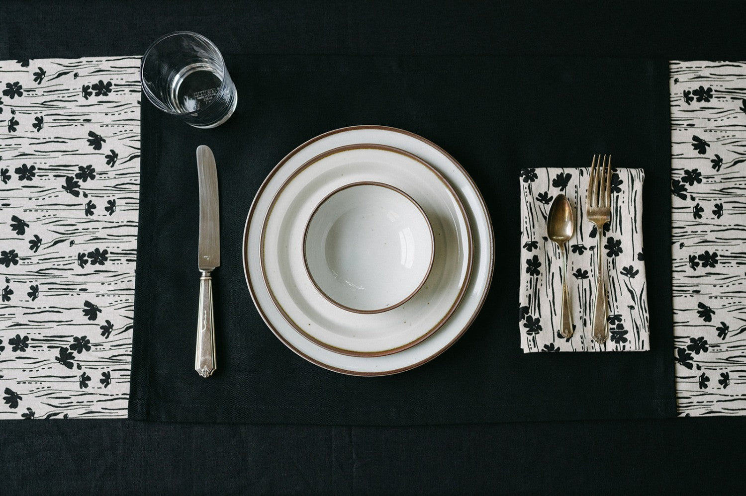 Black placemat setting with white plates and black and white napkins